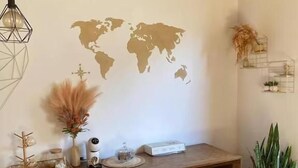 A wooden console table with a world map mural, decorative items, and a potted plant. - Hostel Amor por SP  (São Paulo)