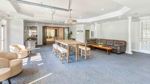 Un'ampia zona giorno con un grande tavolo in legno, comodi posti a sedere e un moderno design del soffitto.