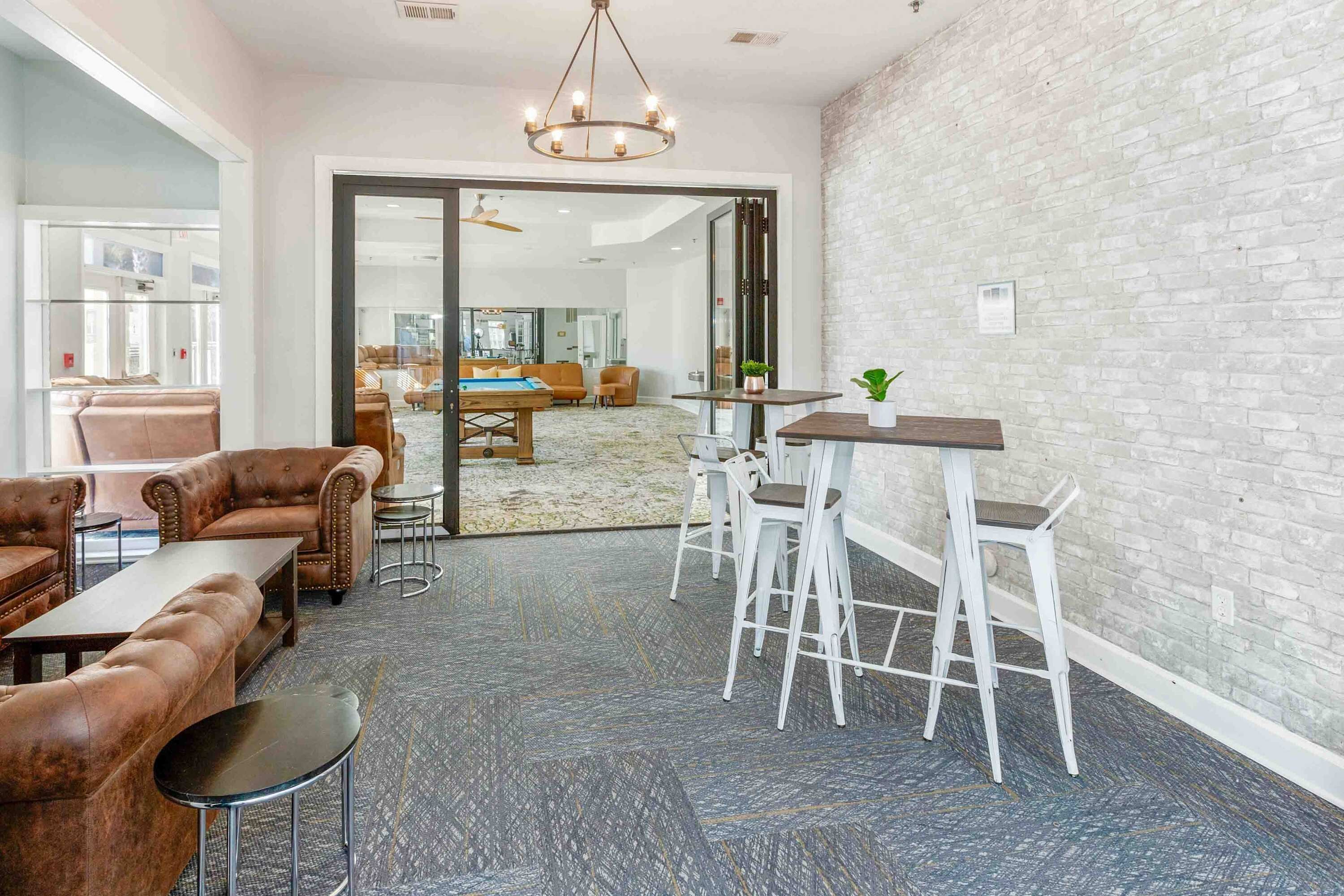 Uma área de estar moderna com sofás de couro, uma mesa de centro e um bar com banquetas.