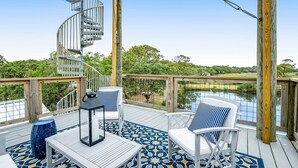 A deck with a spiral staircase, outdoor furniture, and a view of a lake. - Fantastic coastal retreat with private dock, gas grill, two decks, & fast WiFi (Folly Beach)