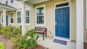 A residential building with a blue front door, a bench outside, and a small garden area. - Snowbird-friendly townhouse with pool, tennis court, & central AC (North Charleston)