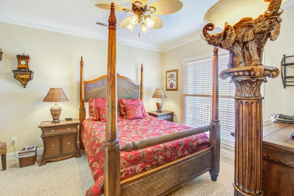 A bedroom with a four-poster bed, a wooden ceiling fan, and a decorative elephant sculpture. - Second-level beachfront villa w/ shared pool, ocean views, & balcony (Folly Beach)