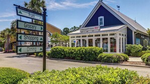 A signpost with directions to Fuel, Grocery, Shopping, and Dining.