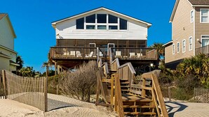 A beachfront house with a balcony and a wooden staircase leading to the deck. - Spacious oceanfront home w/ stunning views, large deck - private access to beach (Folly Beach)