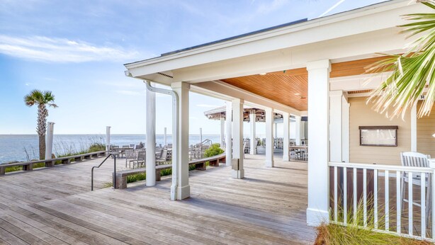 A wooden deck with outdoor seating and a view of the ocean. - Dog friendly villa (Seabrook Island)