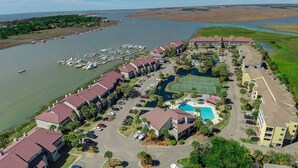 A marina with boats, a swimming pool, and a hotel with red roofs. - Marsh-view condo with on-site pool, tennis, & private balcony (Folly Beach)