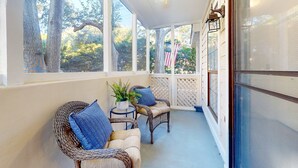 A covered porch with wicker furniture, a ceiling fan, and large windows overlooking trees. - Stylish dog friendly, ground-floor getaway with pool, washer/dryer, & AC (Mt. Pleasant)