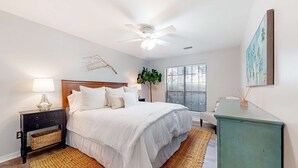 A bedroom with a bed, nightstand, lamp, ceiling fan, and a window with blinds. - Stylish dog friendly, ground-floor getaway with pool, washer/dryer, & AC (Mt. Pleasant)