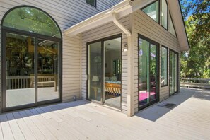 Una casa con ampie porte e finestre in vetro, un patio e un interno arredato.