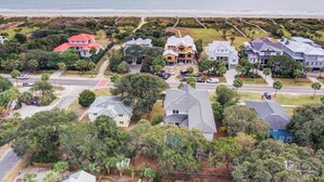 An aerial view of a coastal residential area with houses, roads, and a beach.