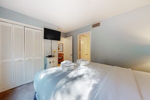 A hotel room with a bed, a TV, a wardrobe, and a desk with a lamp. - Five minute walk to beautiful beaches, golf course views, pet friendly (Kiawah Island)
