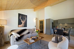 Ein modernes Wohnzimmer mit einer Couch, einem Couchtisch und einem Bild von Hirschgeweihen.