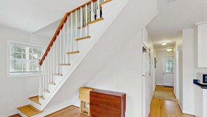 A staircase with white railings and wooden steps leading to a landing. - Amazing Beach Home (Folly Beach)