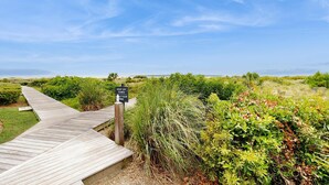 A wooden boardwalk leading through a natural landscape with a sign indicating to keep off dunes and stay on the path. - Condo with sunset views, with ocean/inlet views - walk to the Beach Club (Seabrook Island)