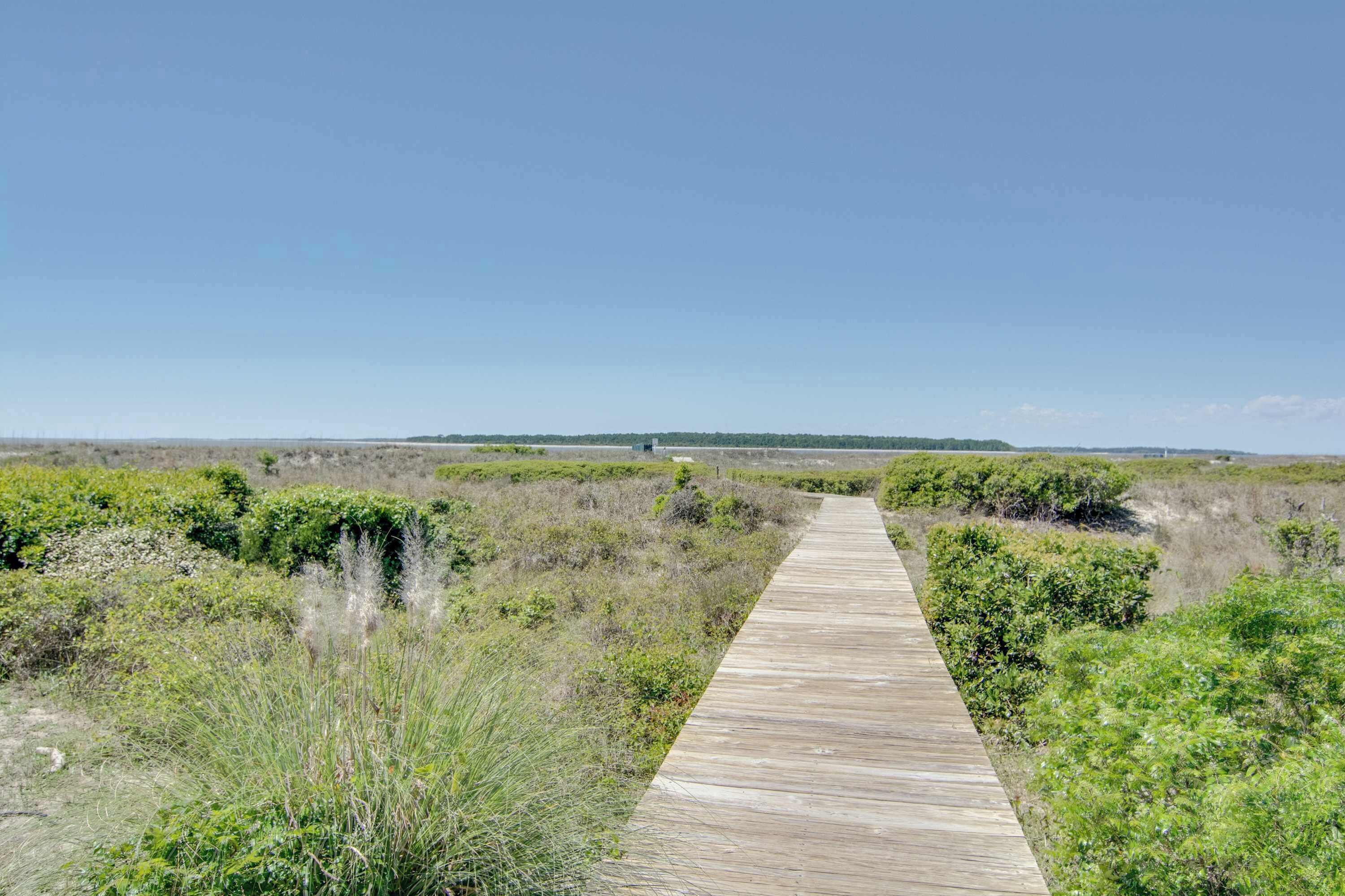 A wooden boardwalk through a natural landscape.