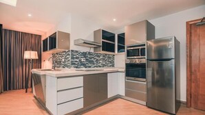 Una cocina moderna con horno integrado, refrigerador de acero inoxidable y salpicadero de azulejos.
