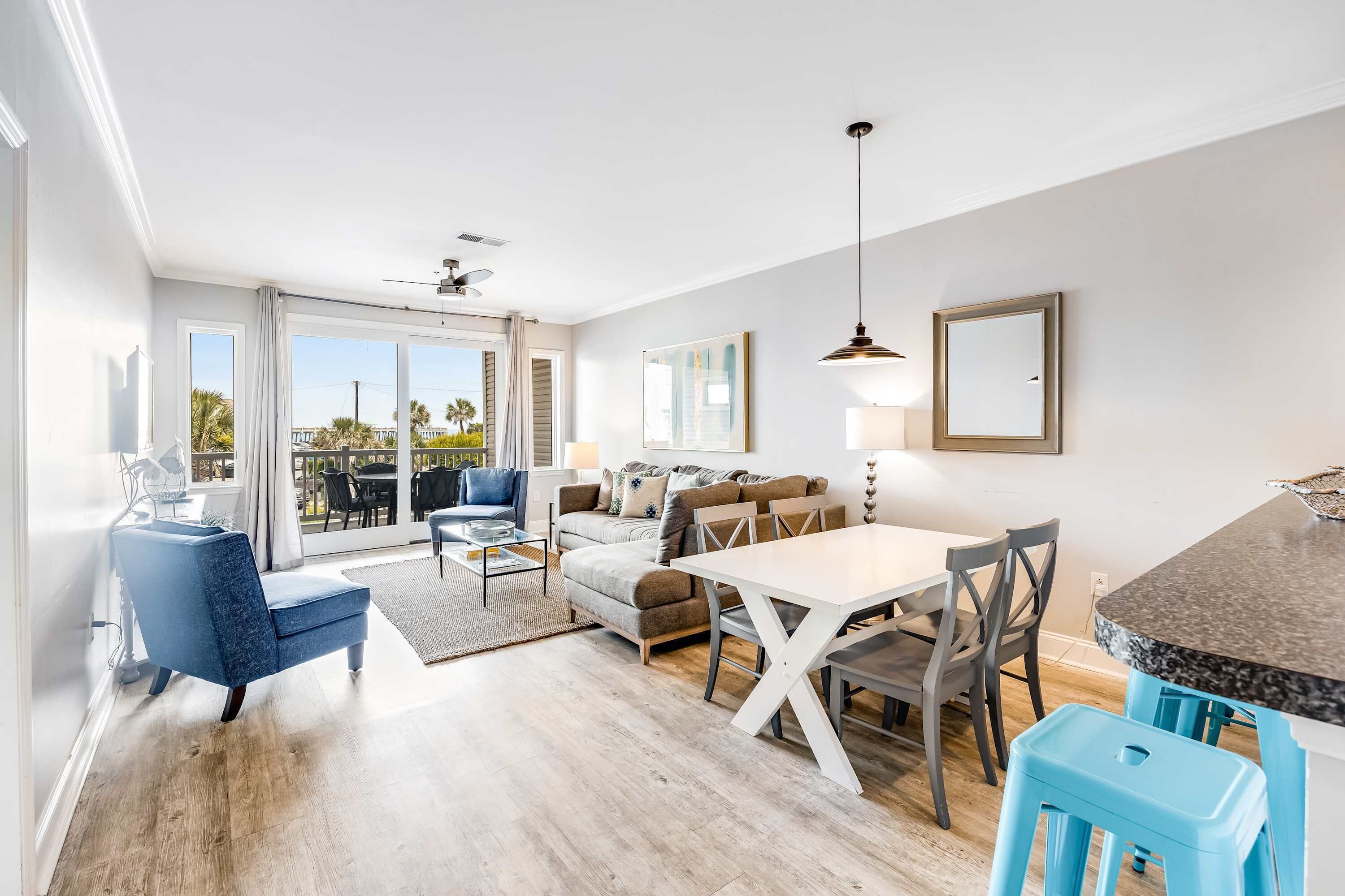 A modern living room with a sofa, coffee table, and dining area with chairs and a table.