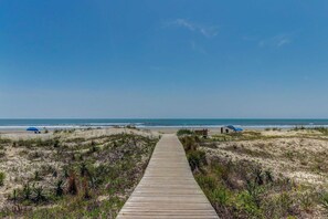A wooden boardwalk leading to a beach with dunes and sparse vegetation. - First floor villa w/ lagoon views from the screened porch - close to Atlantic (Kiawah Island)