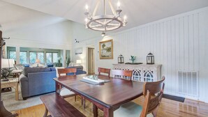 A dining area with a wooden table, chairs, and a chandelier. - Kiawah Resort snowbird hideaway with AC, steps to beach, near golf & tennis (Kiawah Island)