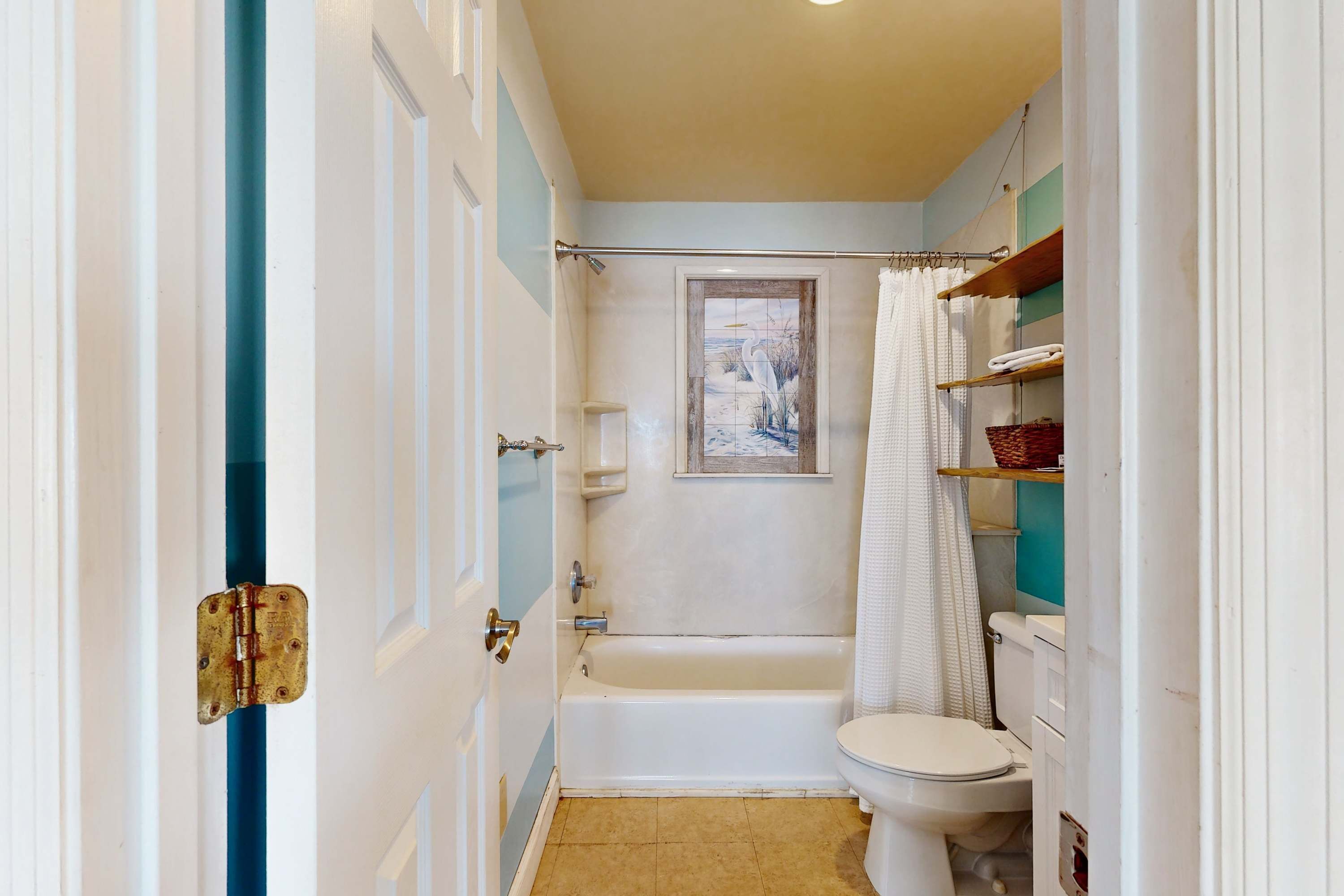 A bathroom with a bathtub, toilet, and a shower curtain.