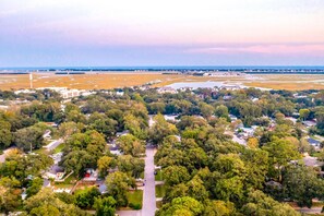 Vista aérea de una zona residencial con casas, calles y una gran masa de agua al fondo.