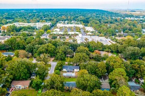 Vista aérea de una zona residencial con casas, árboles y un gran conjunto de edificios.