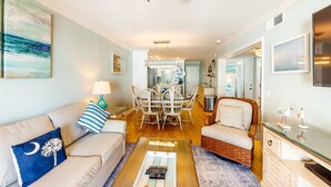 Un salon spacieux comprenant un canapé, une table basse et un coin repas avec des chaises et une table.