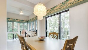 A dining area with a large table, chairs, a bowl, and a chandelier.