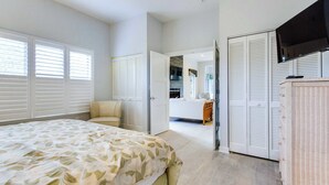 A bedroom with a bed, a dresser, and a walk-in closet.