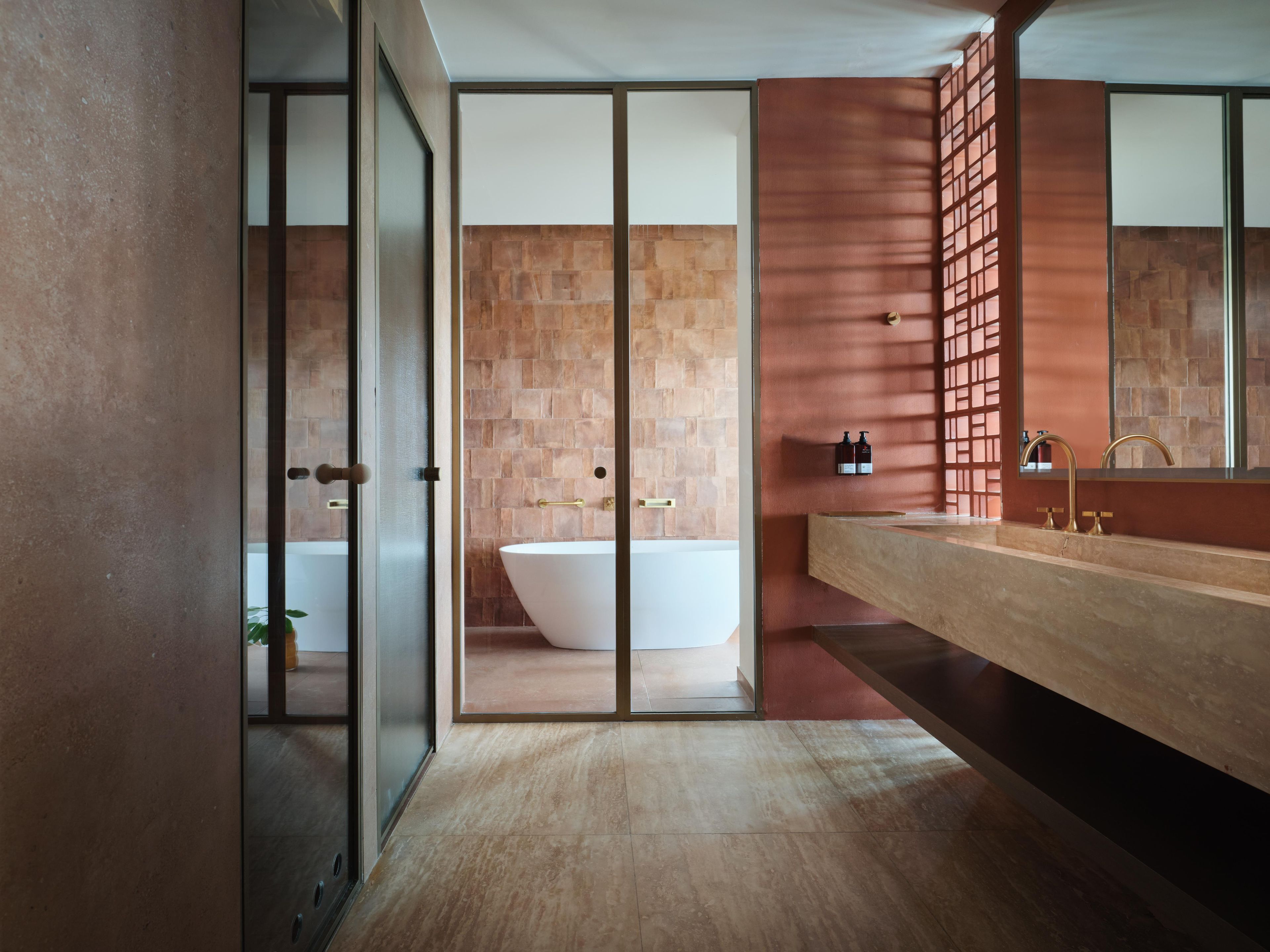 A modern bathroom with a freestanding bathtub, a wooden vanity, and a large mirror.