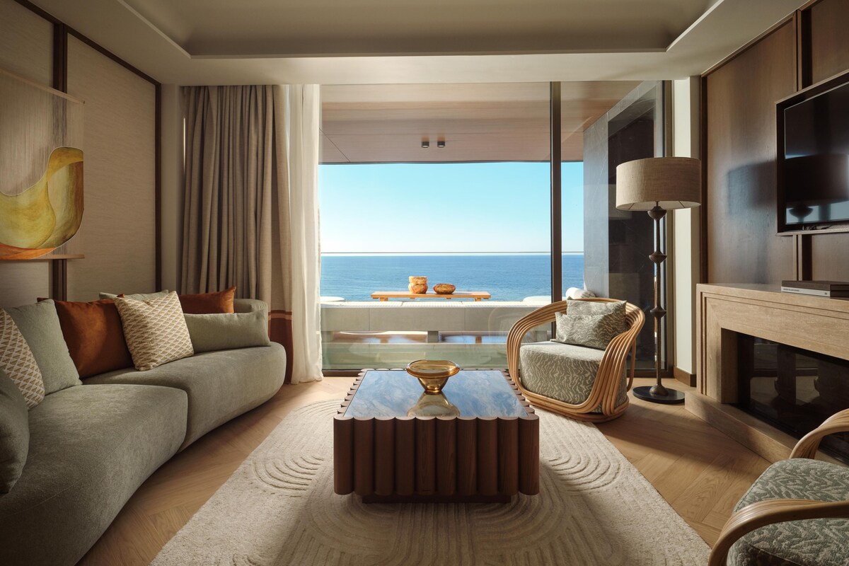 A modern living room with a sofa, armchair, coffee table, and a TV.
