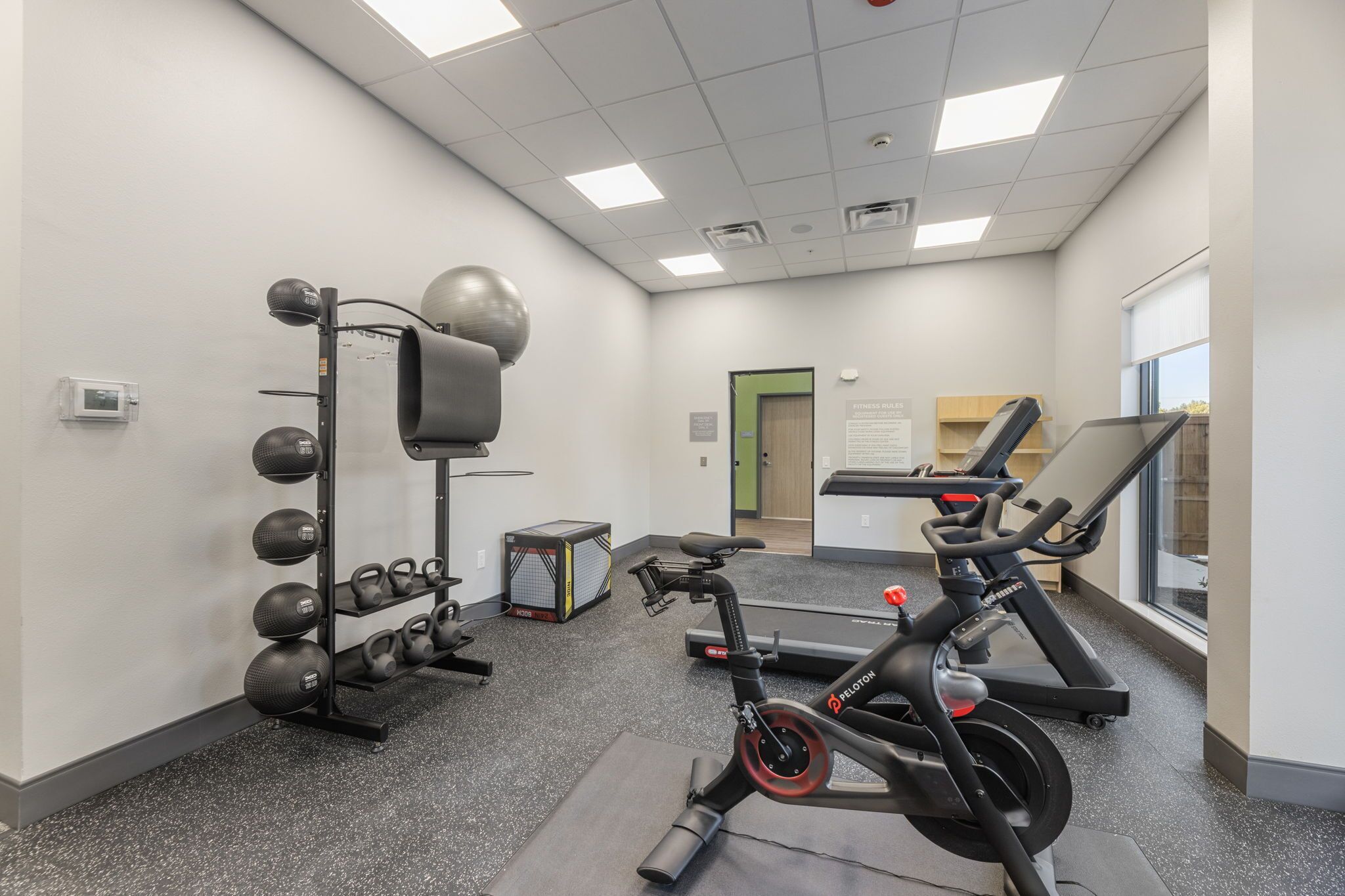 A gym with exercise equipment, a treadmill, and a weight rack.