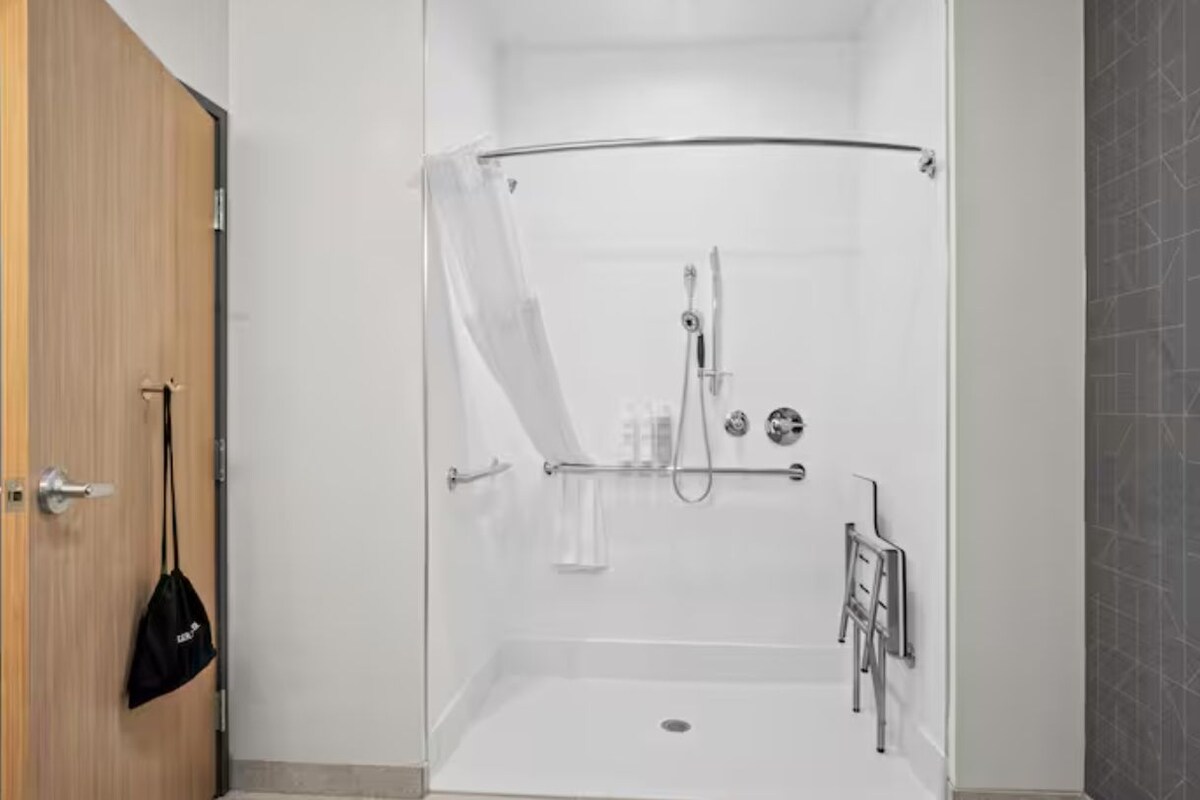 A walk-in shower with a glass door, a towel rack, and a shower caddy.