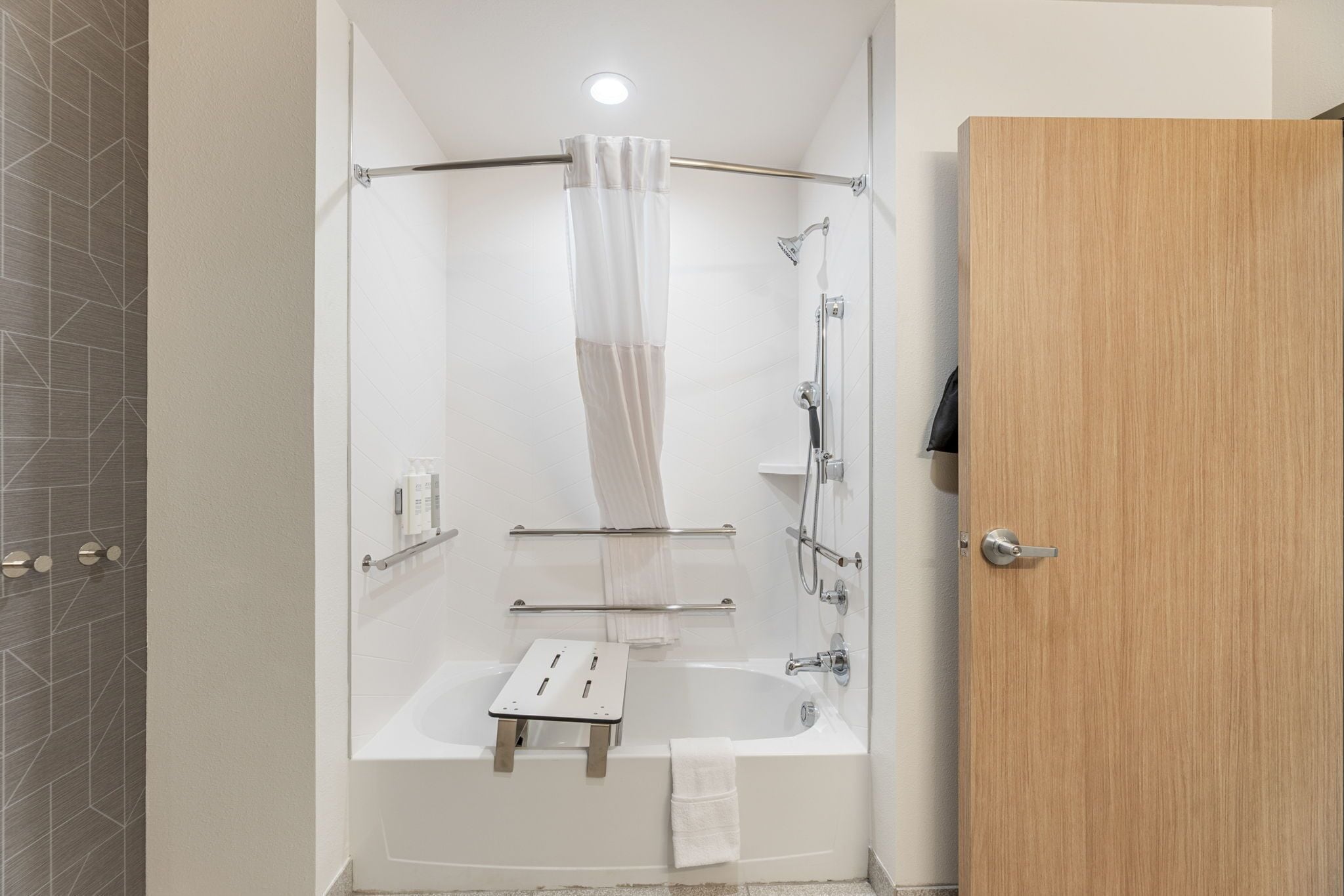 Et moderne badeværelse med bruser, badekar og toilet.