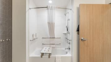 Et moderne badeværelse med bruser, badekar og toilet.