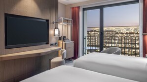 A hotel room with a TV, a desk, a chair, and a bed. - Hilton Istanbul Airport (Arnavutköy)