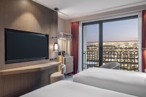 A hotel room with a TV, a desk, a chair, and a bed. - Hilton Istanbul Airport (Arnavutköy)