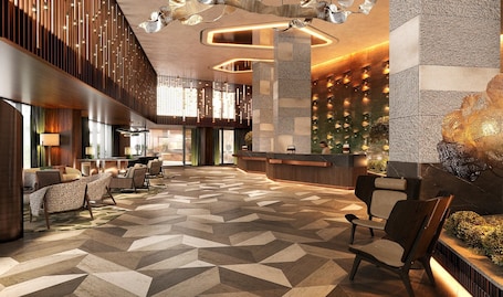 A modern lobby with a geometric patterned floor, a reception desk, and seating areas.
