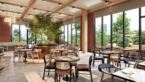A spacious indoor dining area with multiple tables and chairs, large windows offering a view of the city, and a central plant. - Hilton Istanbul Airport (Arnavutköy)