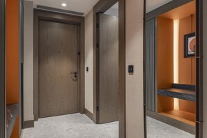 A hotel corridor with wooden doors, a tiled floor, and a framed picture on the wall. - Hilton Istanbul Airport (Arnavutköy)