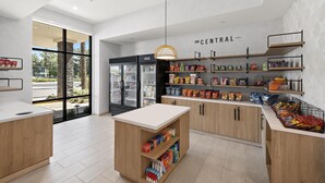 Een modern supermarktonderdeel met houten kasten, een centraal loket en diverse producten op planken.
