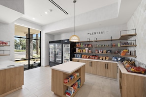 A modern, well-lit snack bar with a variety of packaged goods and a refrigerated display. - Home2 Suites by Hilton Ontario Airport (Ontario)