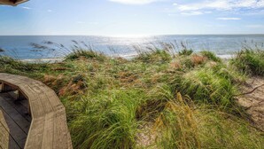 A wooden deck overlooking a beach with a clear view of the ocean. - Comfy Golf View Cottage with WiFi, a Shared Pool, Central AC, Private Washer/Dryer (Seabrook Island)