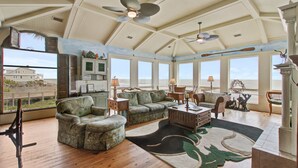A spacious living room with a high ceiling, large windows, and a view of the ocean. - Luxury, Dog-Friendly, Oceanfront Home on Folly Beach (Folly Beach)