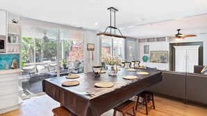 Una cocina amplia con una isla grande, taburetes de madera y vistas al exterior.