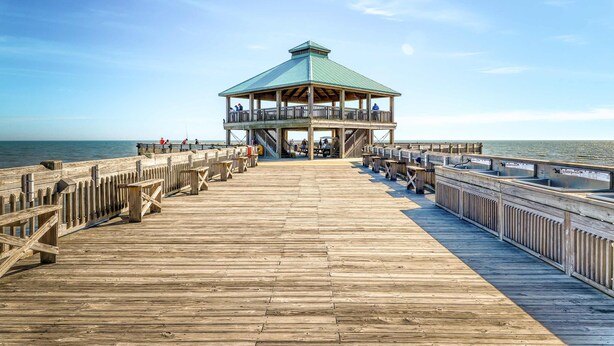 A wooden pier leading to a gazebo with a green roof, overlooking the water. - Raised oceanfront home with elevator & outdoor shower just steps from beach (Folly Beach)
