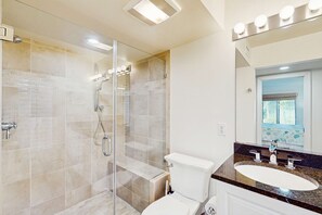 A modern bathroom with a glass-enclosed shower, a white toilet, and a vanity with a sink and mirror. - Lagoon-Front Villa w/ Screened Porch, WiFi & AC - Steps to Beach, Tennis & Golf (Kiawah Island)