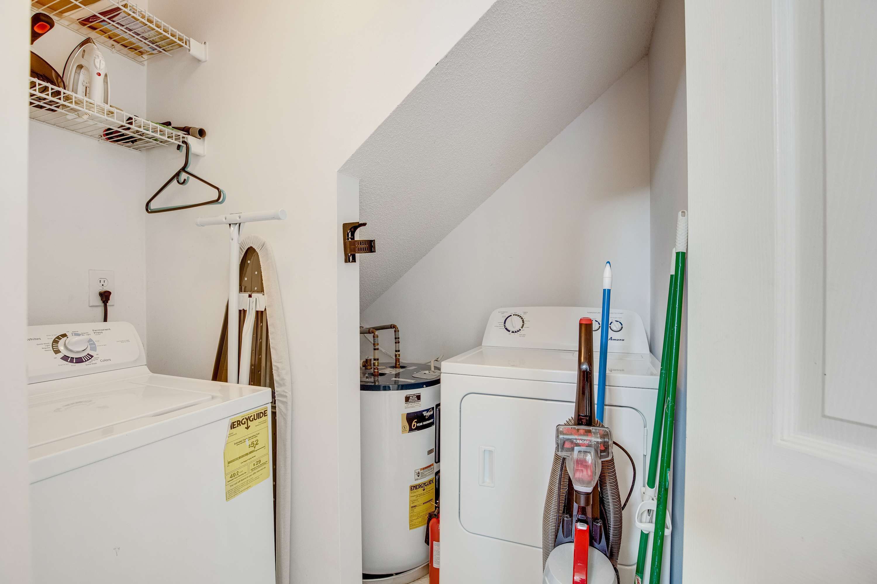 A laundry room with a washer, dryer, and a water heater.