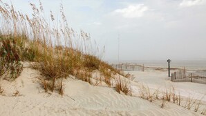 A sandy beach with dunes and sparse vegetation. - Gorgeous home with panoramic ocean views, private pool, & hot tub (Seabrook Island)