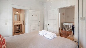Une chambre à coucher avec un lit, une salle de bain avec un miroir et un petit bureau.